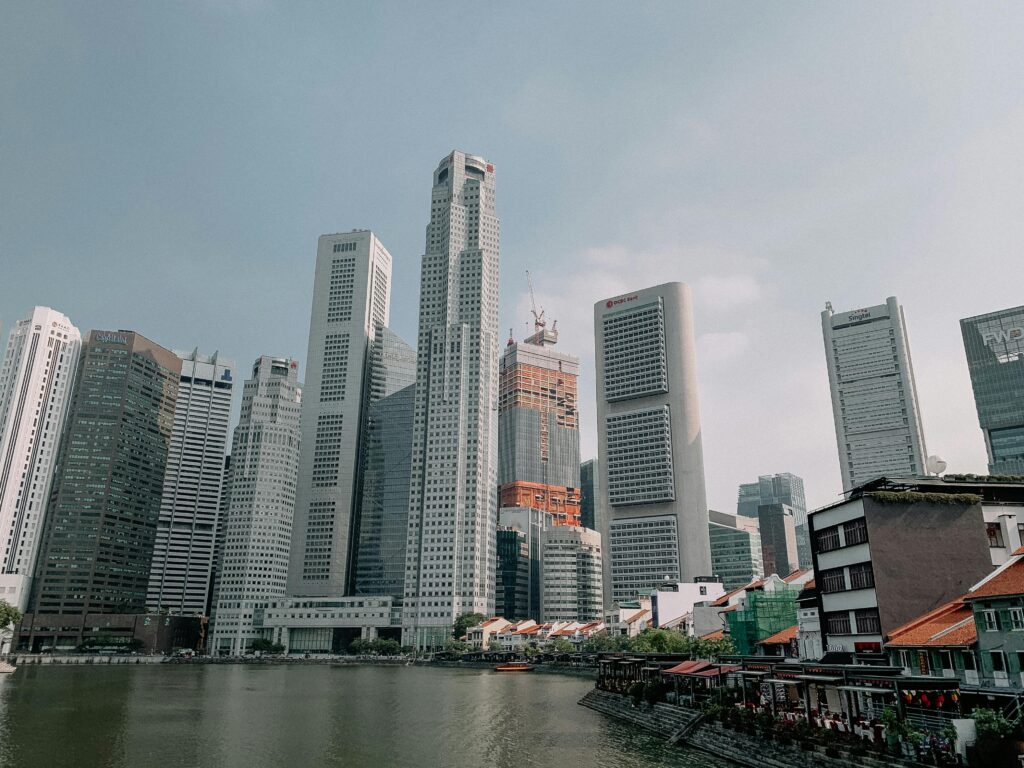Skyline view of modern skyscrapers towering above the Singapore River with clear skies.